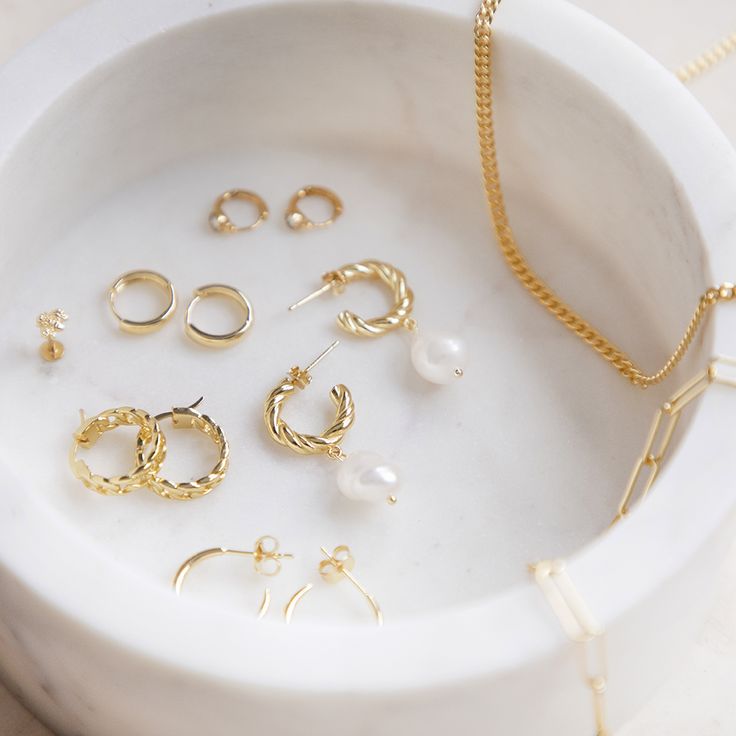 Small gold jewelry casually kept in a marble round box